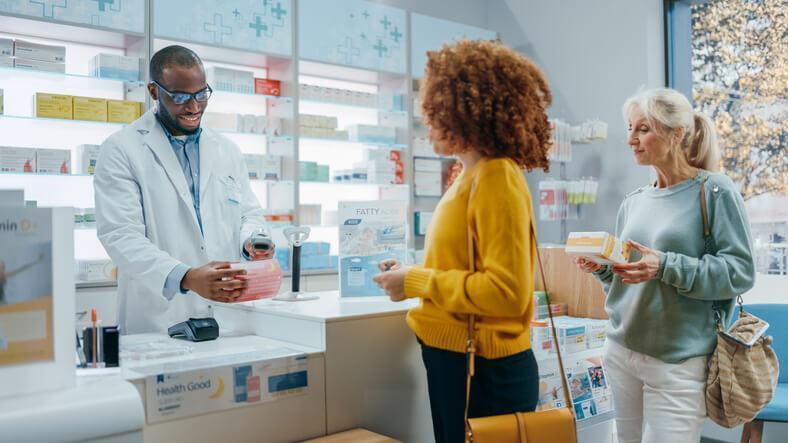 A pharmacy assistant training grad completing purchases for customers