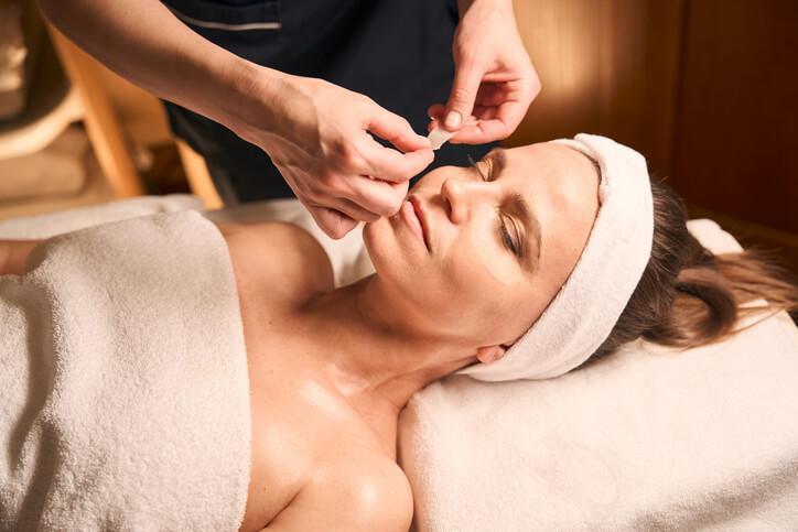 An esthetician performing a facial treatment in a spa setting