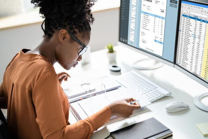 An accounting and payroll course grad working on spreadsheets at a desk