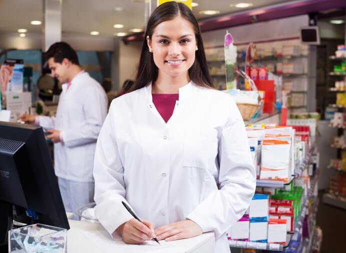 A team of pharmacy assistants consulting a prescription