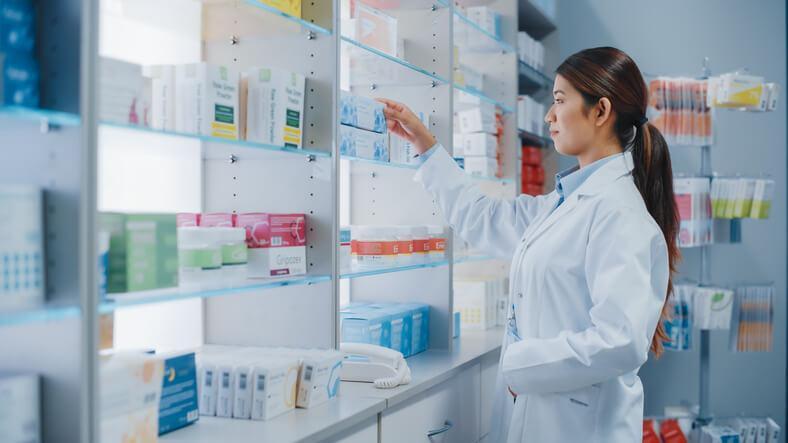 A pharmacy assistant organizing medication at the counter
