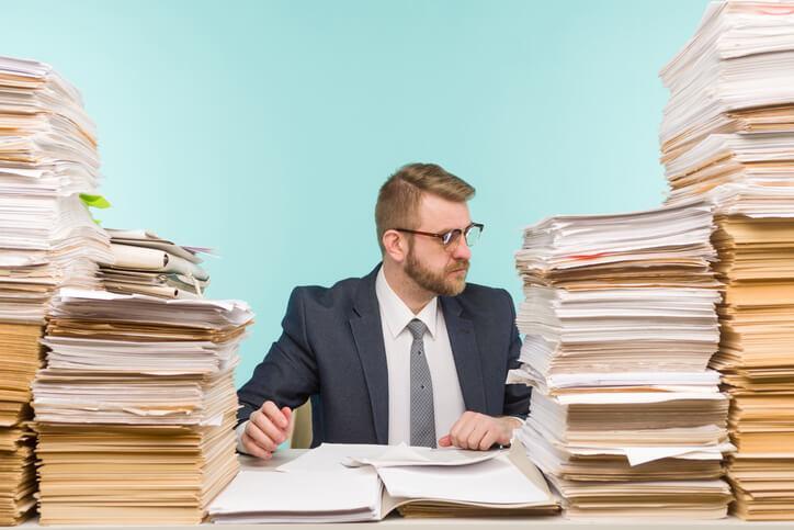 A female law clerk sifting through stacks of legal documents in an office