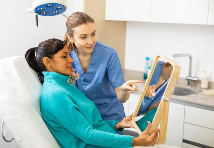 Female medical esthetician examining the face of a female client after completing her medical esthetician training