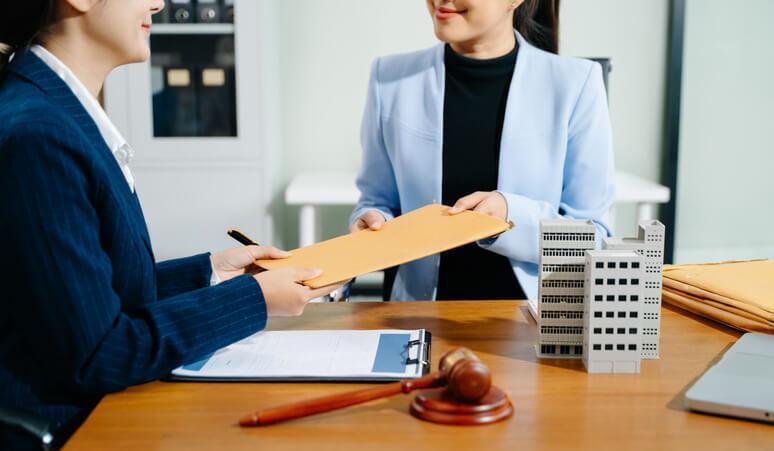 A lawyer and a real estate law clerk are preparing closing documents for property transfer
