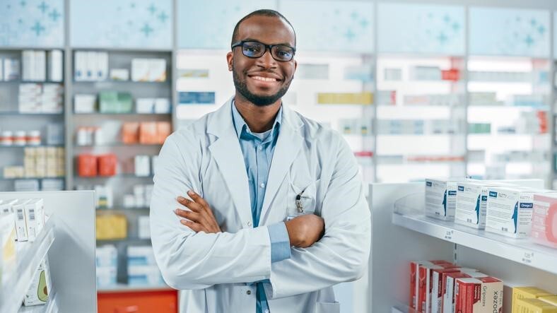 Smiling male pharmacy assistant in a drugstore after completing his pharmacy assistant training