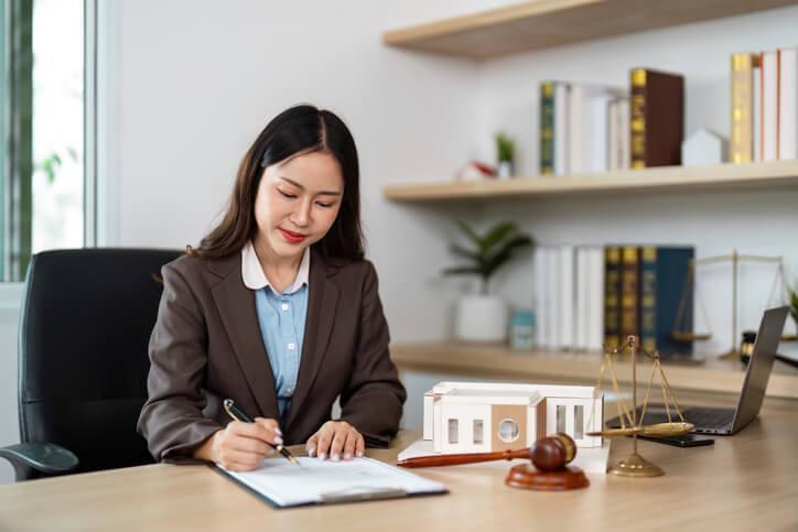 A real estate law clerk reviewing property purchase agreement documents