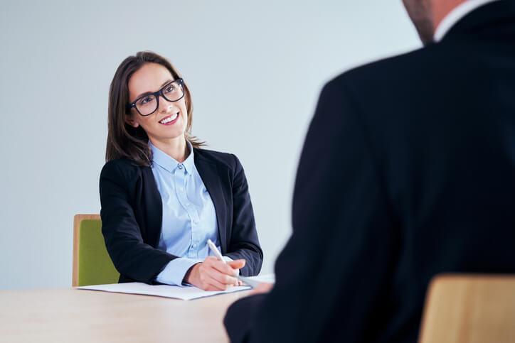 An interviewer smiling as a PSW candidate responds thoughtfully to interview questions for personal support workers.