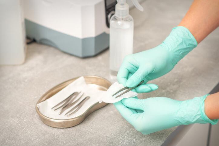Medical esthetics student disinfecting treatment tools before a skincare procedure Medical esthetics student disinfecting treatment tools before a skincare procedure