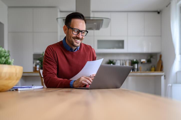 A paralegal working on a laptop in a kitchen after career training