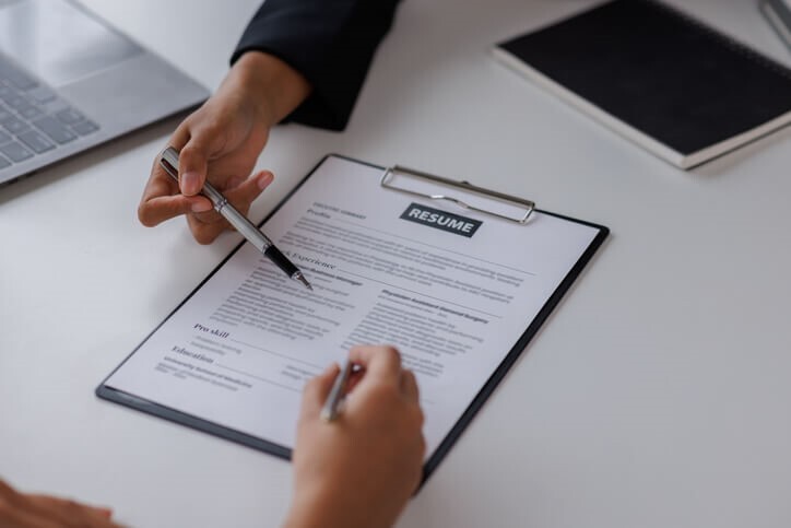 A business management candidate showing their resume to an employer