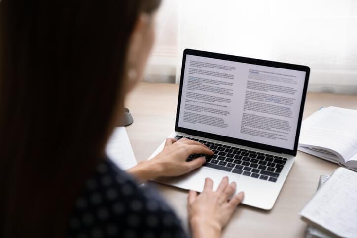 A law clerk training grad working on documents on a desktop computer