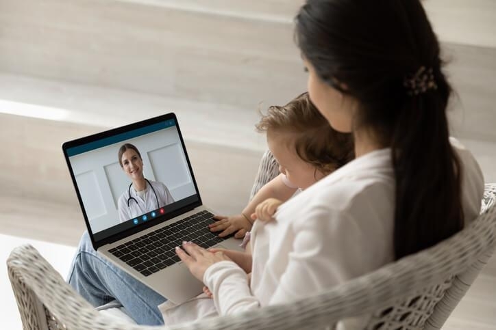 A mother and baby in an online doctor’s appointment facilitated by a medical office assistant training grad