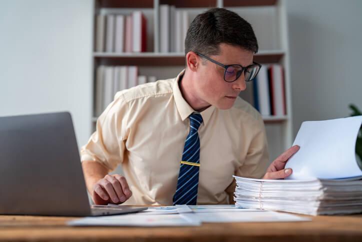 A payroll administrator checks employee records for payroll accuracy