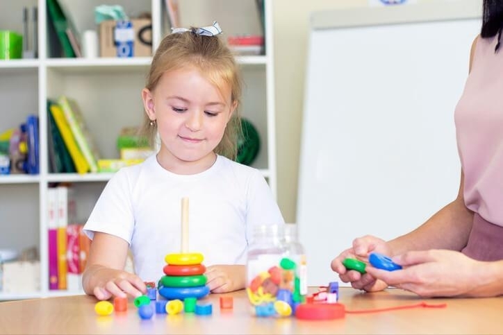 A female early childcare assistant during playtime with a female pupil