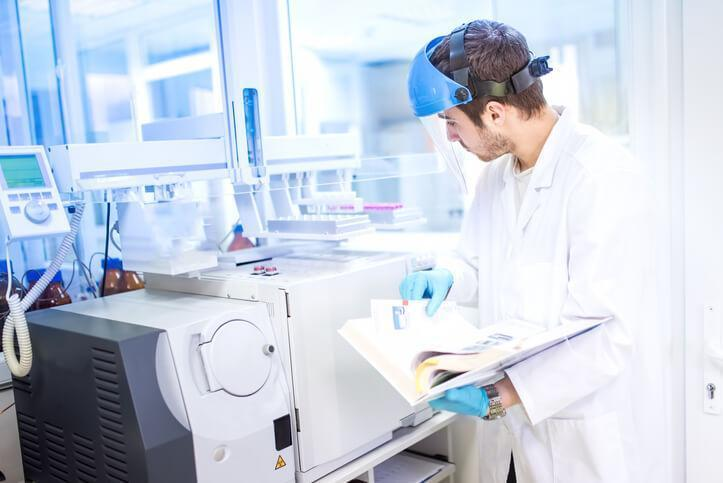 A pharmacy technician student operating laboratory equipment in pharmacy technician training