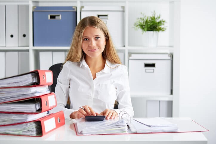 Smiling female payroll clerk in an office after completing her accounting and payroll training