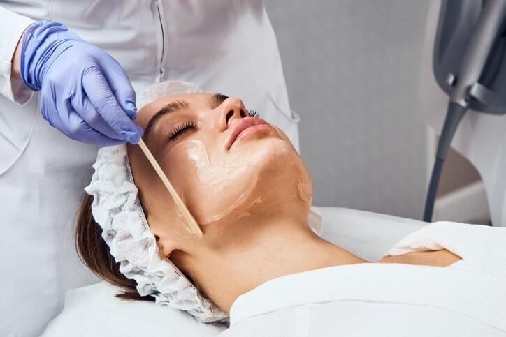 A female medical esthetician giving a female client a chemical peel facial treatment after completing her medical esthetician training