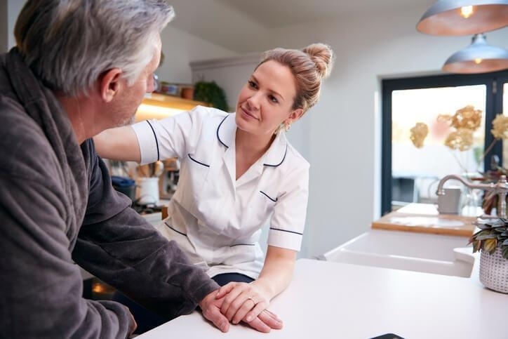 A personal support worker assisting an elderly client at home