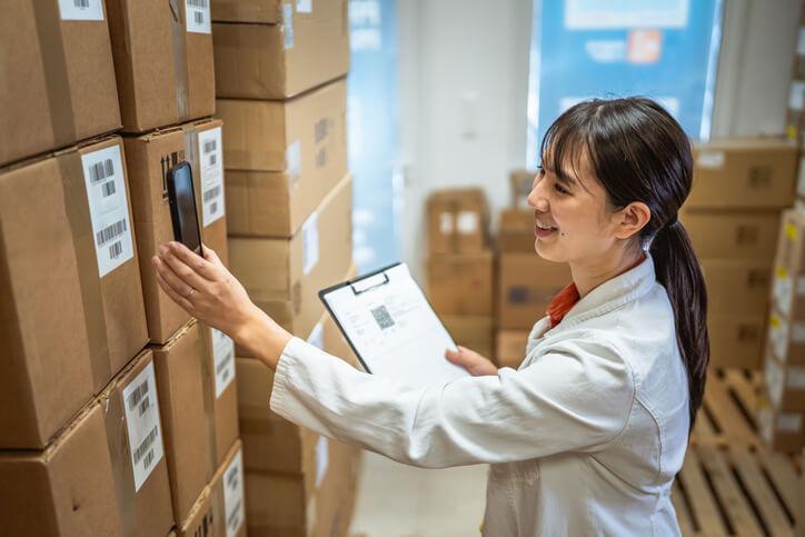 A pharmacy assistant scanning medication boxes for inventory management